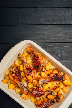 Ahşap masada kızarmış patates ve tavuk eti. 