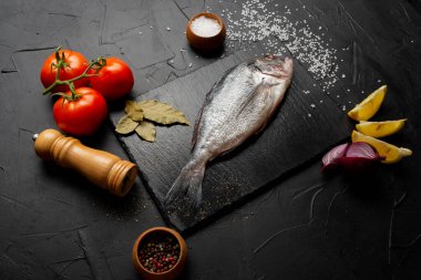 Limon dilimleri, domatesler ve körfez yapraklı lezzetli taze balık manzarası.