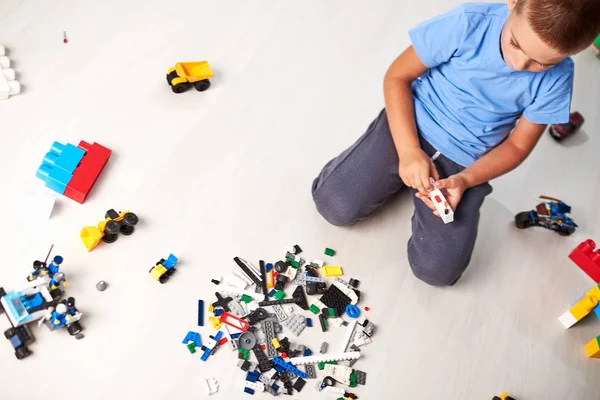 かわいい男の子は建設プラスチック製のおもちゃのブロックで遊んで 子供は家でカラフルなおもちゃを遊んで — ストック写真