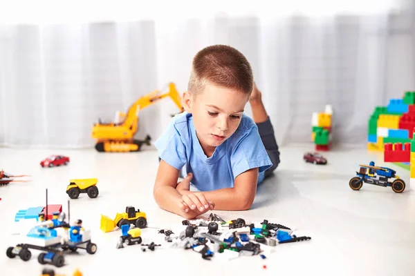 Schattig Jongetje Liggend Vloer Spelen Met Bouw Plastic Speelgoed Blokken — Stockfoto