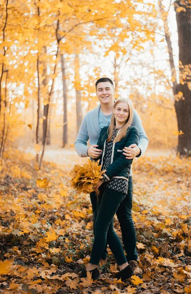 快乐的年轻夫妇一起站在秋天的森林里拥抱 — 图库照片