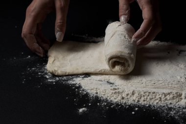 Siyah arka planda taze ev yapımı hamur işi hazırlayan kadının yakın plan görüntüsü 