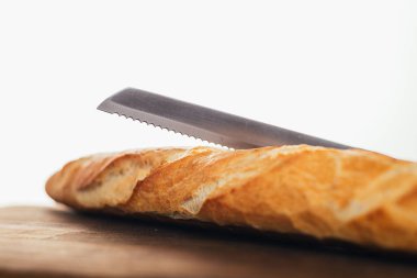 Beyaz arka plandaki ahşap masada nefis taze ekmek ve bıçak manzarası.