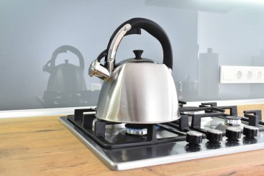 Mutfaktaki ocağın üzerindeki metal çaydanlığın yakın çekim görüntüsü.