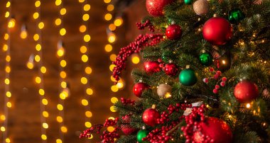 Parlak kırmızı ve yeşil mücevherleriyle süslenmiş güzel Noel ağacı.
