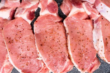 Kesme tahtasındaki baharatlı taze çiğ bifteklerin üst görüntüsü. 