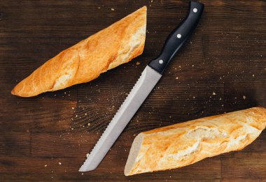 Lezzetli ev yapımı ekmek ve ahşap masadaki bıçak manzarası.