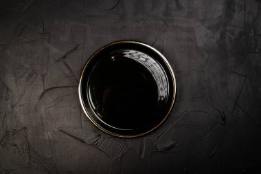 Siyah arkaplanda boş yuvarlak tabağın üst görünümü