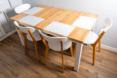 Modern yemek odasındaki beyaz sandalyeli ahşap masanın yüksek açılı görüntüsü. 