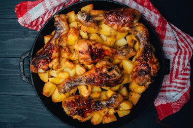 Ahşap arka planda eti olan lezzetli fırında patateslerin yakın plan görüntüsü.