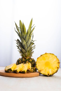 Beyaz arka planda tahta üzerinde taze dilimlenmiş ananasın yakın plan görüntüsü 