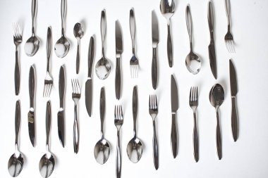 Beyaz arkaplanda parlak gümüş çatal bıçak setinin üst görünümü