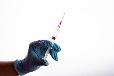 Eldivenli doktorun beyaz arka planda aşısı olan bir şırınga tutarken görüntüsü.
