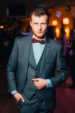 Partide takım elbiseli yakışıklı bir adam