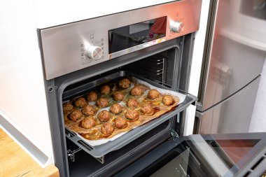 close-up view of delicious cooked meatballs on baking tray in oven