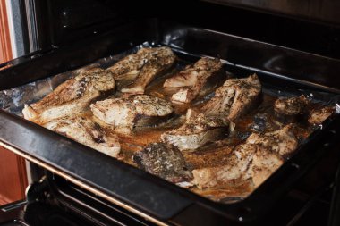 Pişirme tepsisindeki baharatlı lezzetli balıkların yakın plan görüntüsü.