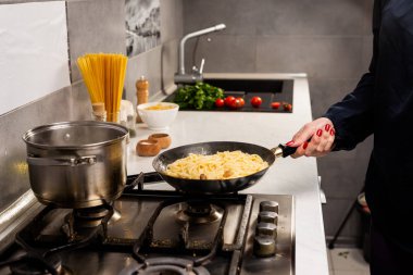 Mutfakta nefis İtalyan makarnası pişiren kişinin kısmi görüntüsü