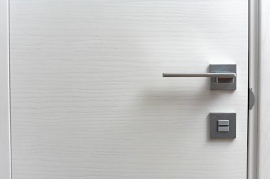 close-up view of modern white door with metal handle indoors