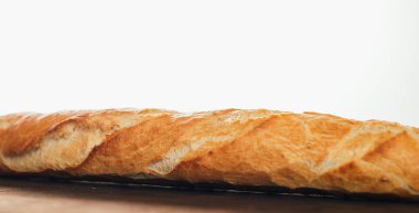 Beyaz arka plandaki ahşap masada nefis taze ekmeğin yakın plan görüntüsü.