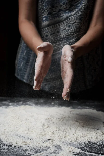 小麦粉をふるいにかけ黒を背景に生地を作る女性の中央部 — ストック写真