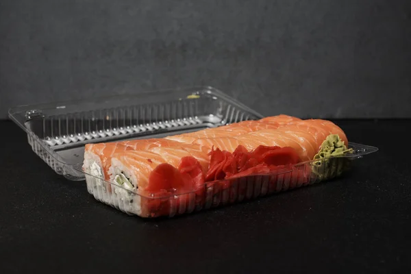 Vista Close Deliciosos Rolos Sushi Tradicionais Recipiente Plástico Fundo Preto — Fotografia de Stock