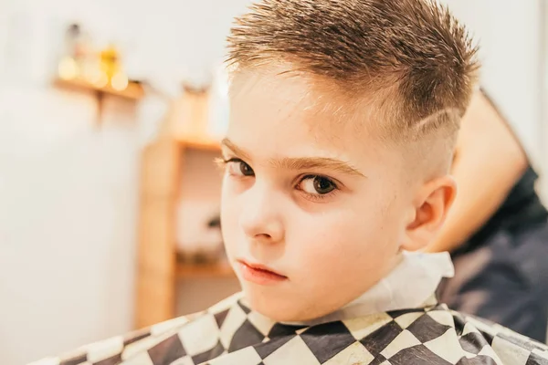 Adorável Menino Sentado Olhando Para Câmera Barbearia — Fotografia de Stock