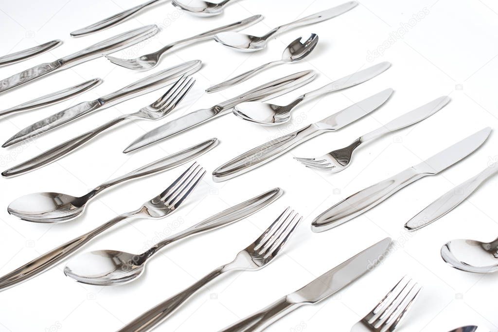 close-up view of forks, spoons and knives on white background  