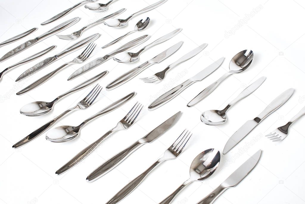 close-up view of forks, spoons and knives on white background  