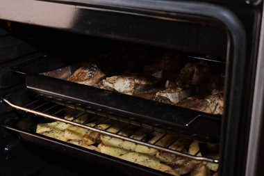 Fırında pişirme tepsisindeki baharatlı lezzetli balıkların yakın plan görüntüsü.