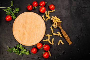 Lezzetli pişmemiş makarnanın üst görüntüsü ve siyah yüzey malzemeleri.