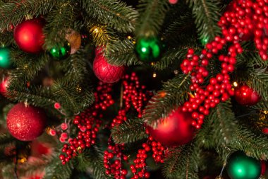 Parlak kırmızı ve yeşil mücevherleriyle süslenmiş güzel Noel ağacı.