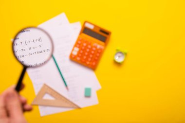 Sarı arka planda hesap makinesi ve ofis malzemeleri  