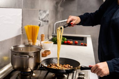Mutfakta gurme İtalyan makarnası pişiren kişinin kısmi görüntüsü