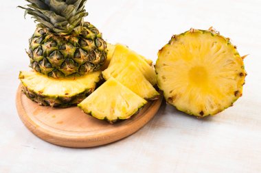 Beyaz arka planda tahta üzerinde taze dilimlenmiş ananasın yakın plan görüntüsü
