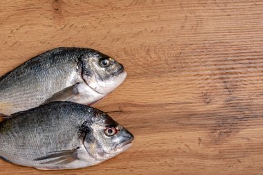 Tahta masadaki taze çiğ balığın yakın plan görüntüsü.
