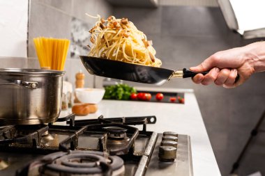 Mutfakta nefis İtalyan makarnası pişiren kişinin kısmi görüntüsü