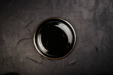 Siyah arkaplanda boş yuvarlak tabağın üst görünümü