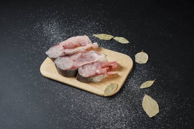 Siyah yüzeyde baharatlı ve defne yapraklı lezzetli balıkların yakın plan görüntüsü