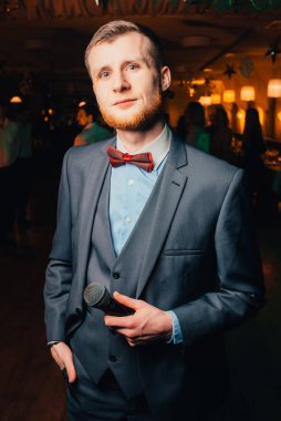 Üzerinde mikrofon olan takım elbiseli bir adam.