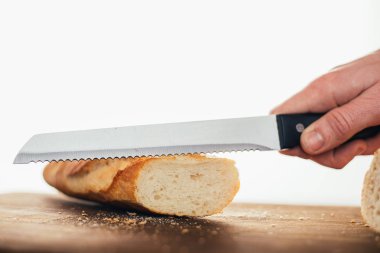 Bıçak tutan ve ekmek kesen birinin kesilen görüntüsü.
