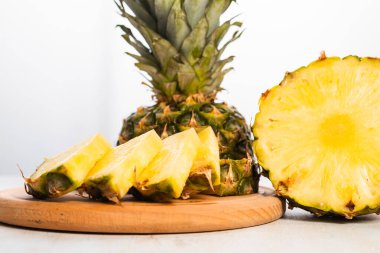 Tahta tahtada beyaz zemin üzerinde taze kesilmiş ananasın yakın plan görüntüsü