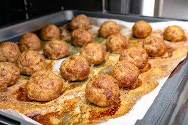 close-up view of delicious cooked meatballs on baking tray in oven
