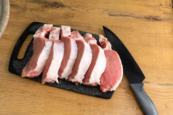 Bovenaanzicht Van Ongekookte Steaks Met Kruiden Snijplank Mes Houten Tafel — Stockfoto