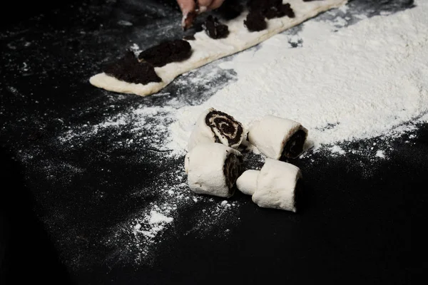 cropped shot of woman cooking sweet poppy seed buns on black background