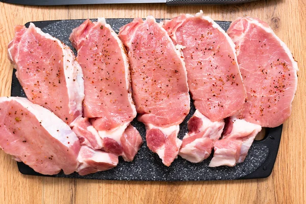 Bovenaanzicht Van Verse Ongekookte Steaks Met Specerijen Snijplank Houten Tafel — Stockfoto