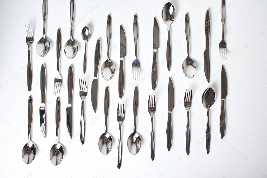 top view of forks, spoons and knives on white background 