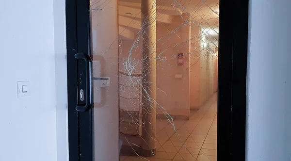 Janelas da porta da frente de vidro quebrado de apartamentos de uma residência vista da rua . — Fotografia de Stock