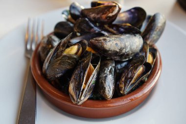 Yağlı, sarımsaklı ve maydanozlu sotelenmiş midye.