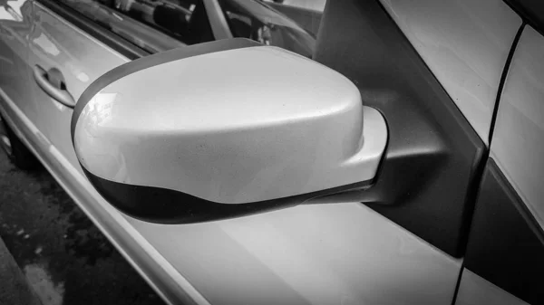 Closeup of a side view car mirror. Passenger side Silver car. Black and white style — 스톡 사진