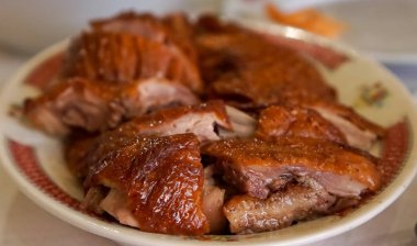 Closeup on peking roast duck, with crisp skin, cut into pieces, imperial meal in a restaurant